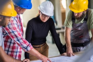 construction workers going over a blueprint with their foreman