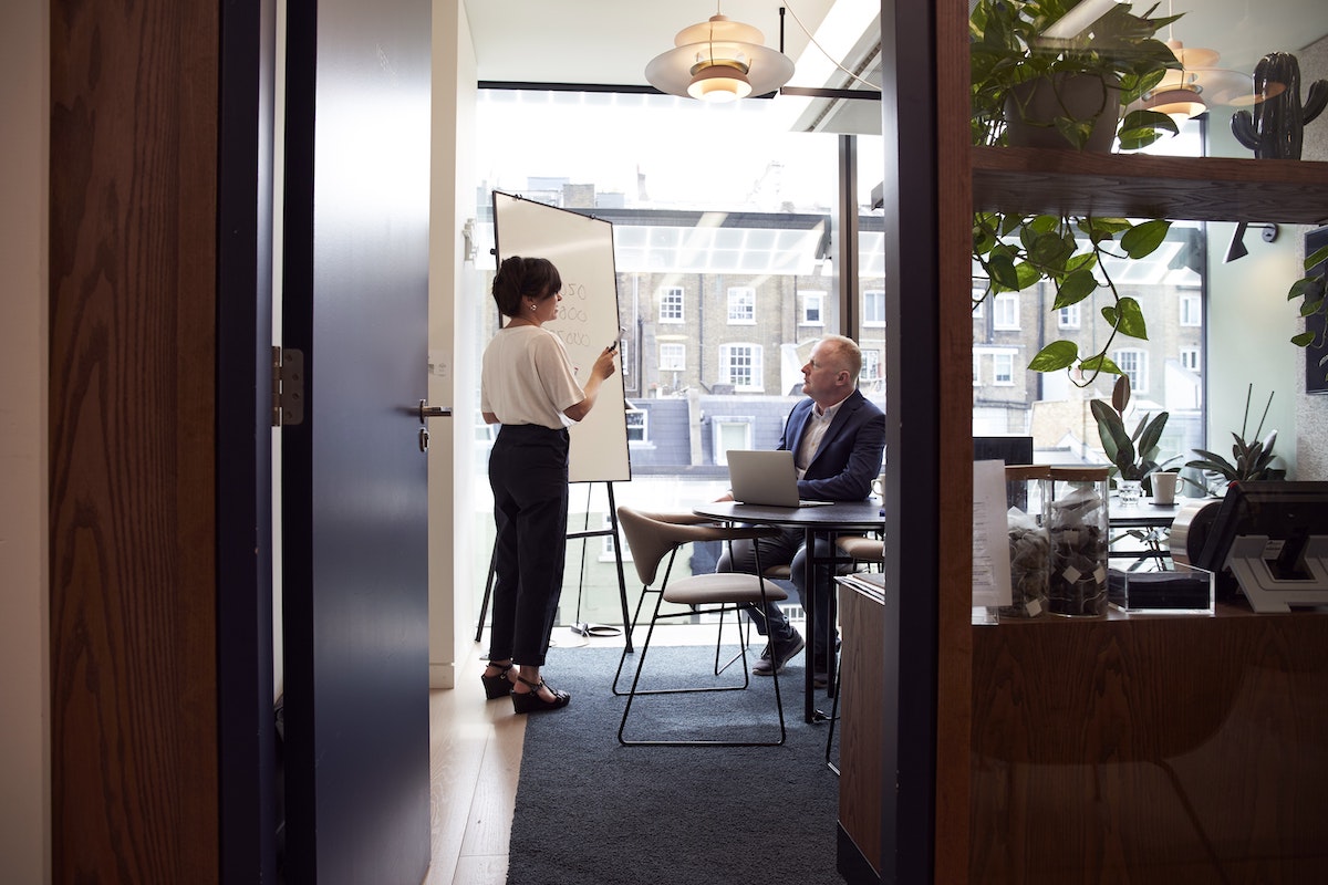 people discussing whiteboard in office